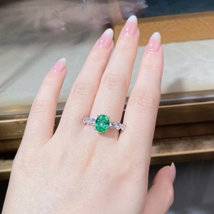 Macro shot of 3ct oval Paraiba green gemstone on S925 sterling silver ring worn on hand