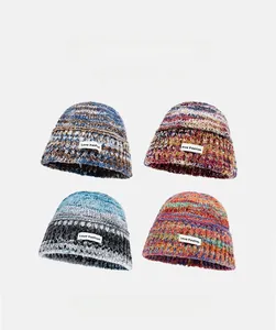 Close-up of thick knitted beanies with colorful gradient textures and fashion woven labels
