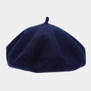 Detail of navy blue wool beret featuring thick felt texture and top decorative stem