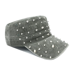 Detailed close-up of dark grey washed denim military cap with punk silver metal studs