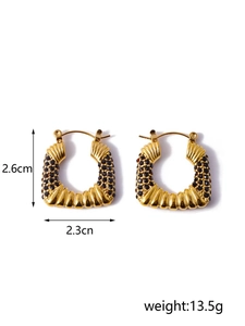 Detail of gold C-shaped earrings with black zircon pavé, 2.6cm height, 2.3cm width
