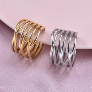 Macro shot of gold and silver multi-layer wrap rings on a white plate and pink fabric