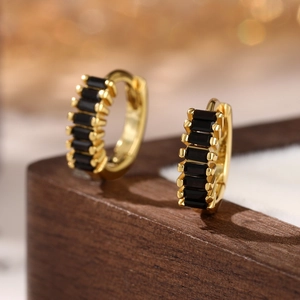 Macro shot of 925 silver hoop earrings with channel-set black rectangular zircons