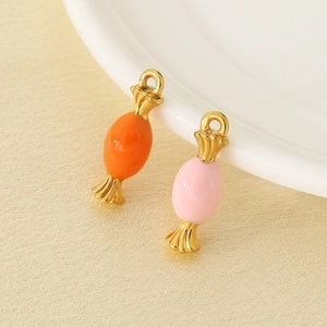 Macro detail of pink and orange enamel candy pendants with gold metal ends for DIY jewelry