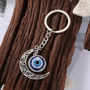 Silberner Evil Eye Mond-Schlüsselanhänger mit Filigranmuster und blauem Harz-Anhänger