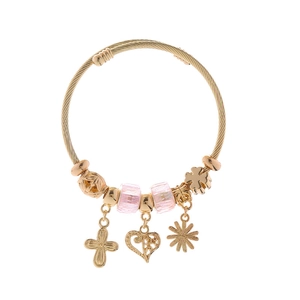 Detail eines goldfarbenen Armreifs mit rosa Perlen und Blumenanhängern auf weißem Hintergrund