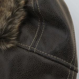 Detail of dark brown faux leather trapper hat with thick fur lining and contrast stitching