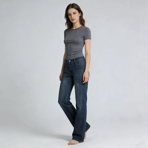 Macro detail of high-waisted dark blue denim jeans paired with a grey knit crop top