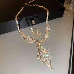 Close-up of sparkling leaf-shaped gold necklace and earring set with crystals