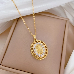 Macro detail of gold oval Virgin Mary pendant with white zircons and hollow heart border