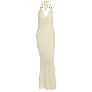 Detail of yellow halter neck dress featuring deep V-neck and tortoiseshell ring accents