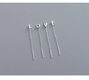 Detail of silver S999 LOVE letter drop earrings with delicate chains and polished finish