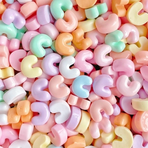 Macro shot of colorful macaron resin C-shaped charms for phone cases and DIY crafts