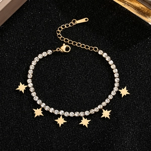 Gold-plated star charm bracelet with shimmering cubic zirconia stones on a black surface