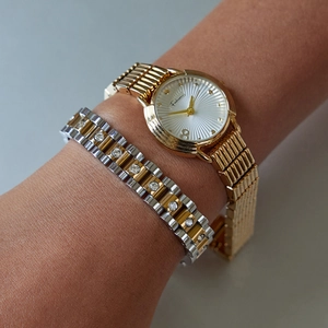 Detail of vintage 18k gold plated watch and sparkling zircon studded chain bracelet
