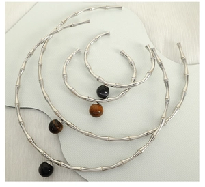 Detail of silver bamboo choker set with tiger eye and black stone spherical pendants