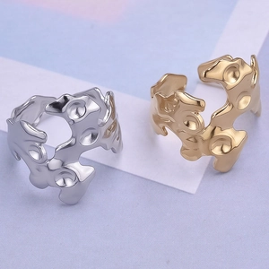 Detail of irregular lava texture on gold and silver stainless steel open rings