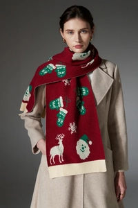 Detail of red Christmas knitted scarf with reindeer and snowflake patterns