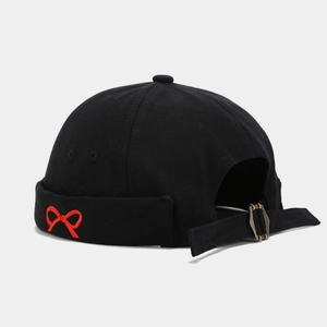 Detail of black docker cap with red bow embroidery and adjustable metal buckle strap