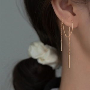 Close-up of golden tassel ear threader earrings with celestial stars on model