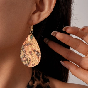 Détail des boucles d'oreilles en liège à motif paisley portées par un mannequin