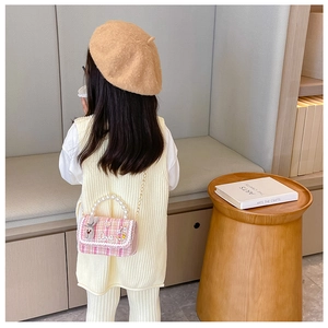 Pink tweed kids handbag with pearl handle and Love lettering shown on model