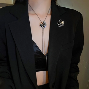 Détail du collier camélia avec gland et émail noir porté par un mannequin