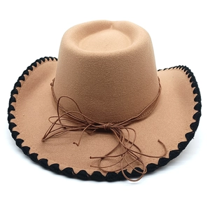 Close-up of camel western felt hat with black woven edge and decorative brown cord tie
