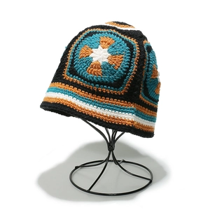 Bohemian granny square crochet bucket hat with vibrant floral patterns on display stand