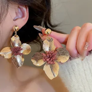 Brushed gold metal flower drop earrings with reddish stamen clusters for a vintage look