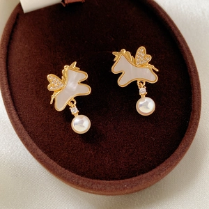 Détail des boucles d'oreilles licorne plaquées or 18k avec perles et nacre