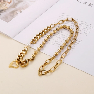 Gros plan d'un collier doré à double couche avec pendentif cœur et perle sur un magazine