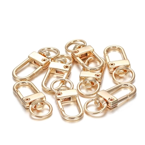 Detail view of eight polished golden metal swivel lobster clasps for DIY bag accessories