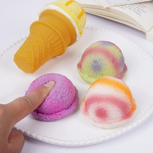 Jouet squishy crème glacée colorée en PU sur plateau blanc avec décor de livre ouvert