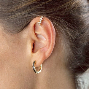 Minimalist gold hoop earrings with black zircon stones and a sparkling ear cuff