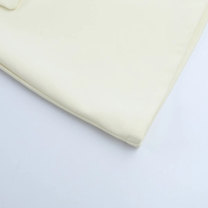 Detailed macro view of beige twill fabric texture and professional stitching on skirt suit
