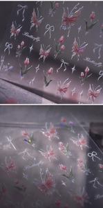 Macro shot of 3D laser tulip and pink butterfly nail stickers with glitter finish