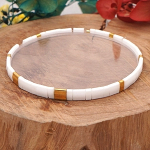 Bohemian Tila bead stretch bracelet with white and gold beads on natural wood