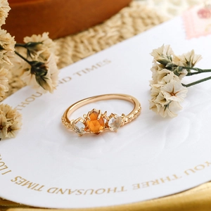 Foto macro de anillo de oro vintage con granate naranja y piedras de cristal blanco