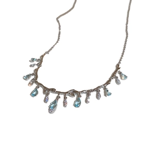 Minimalist irregular geometric necklace with light blue teardrop pendant and silver tassel