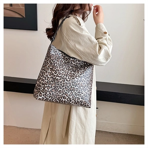 Detailed view of large leopard print tote bag featuring black slim straps and PU leather