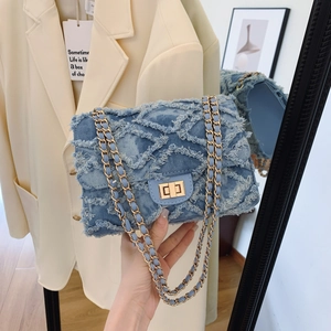 Blue denim crossbody bag with gold lock and chain strap shown in mirror selfie