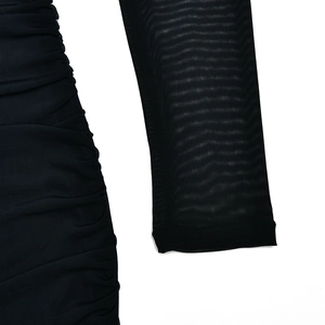 Détail de manches longues en tulle noir transparent avec texture froncée sur la robe