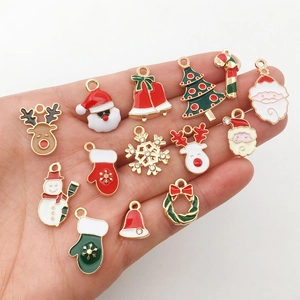 Close-up of mixed Christmas alloy enamel charms held in hand for DIY jewelry making