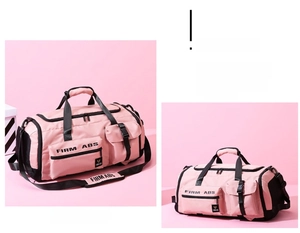 Detail of pink travel bag showing multiple zipper pockets and adjustable shoulder strap
