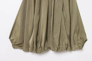Detailed close-up of olive green pleated hem with subtle sheen and elastic bubble edge