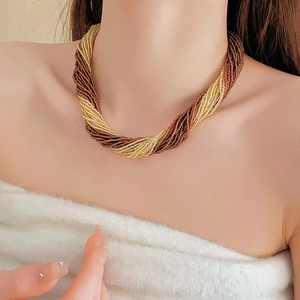 Detail of French vintage layered necklace with twisted brown and gold seed beads on model