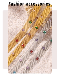 Close-up of gold and silver mesh bracelets with colorful crystals on white sand