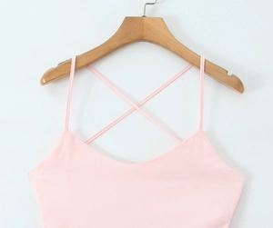 Detailed view of the V-neckline and thin straps of a pink satin dress on a hanger