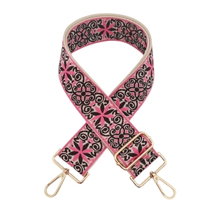 Detailed close-up of ethnic embroidery texture and golden alloy buckle on wide bag strap